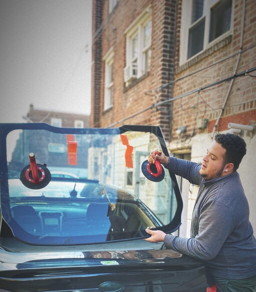 Technician setting new back glass with suction cups